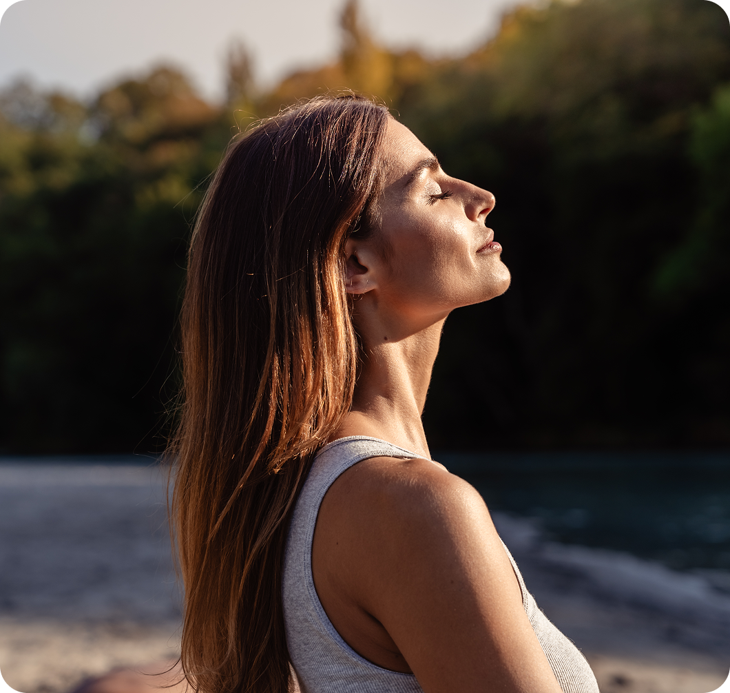 Woman enjoying nature with eyes closed.