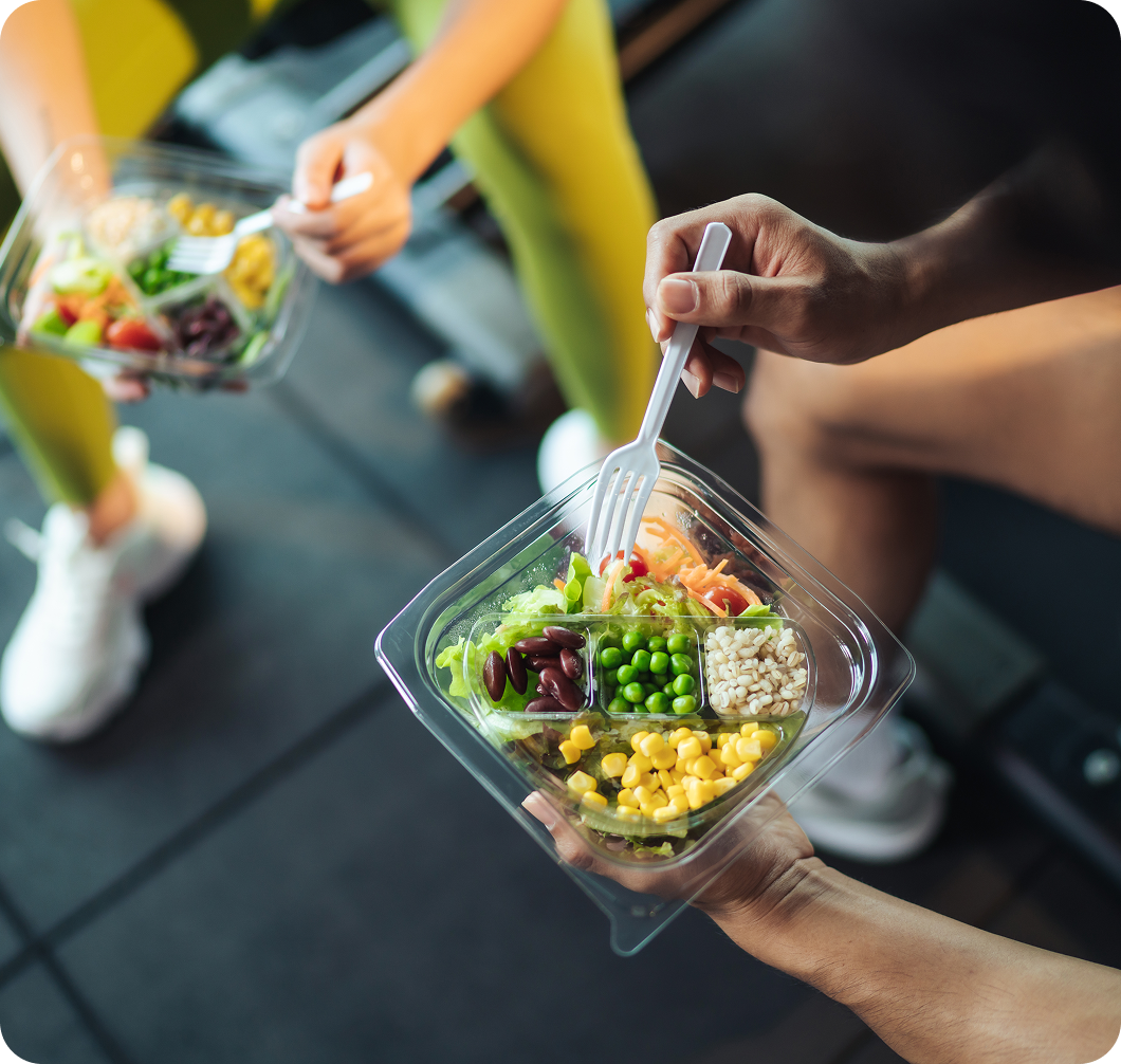 People holding bowls of fresh salad.
